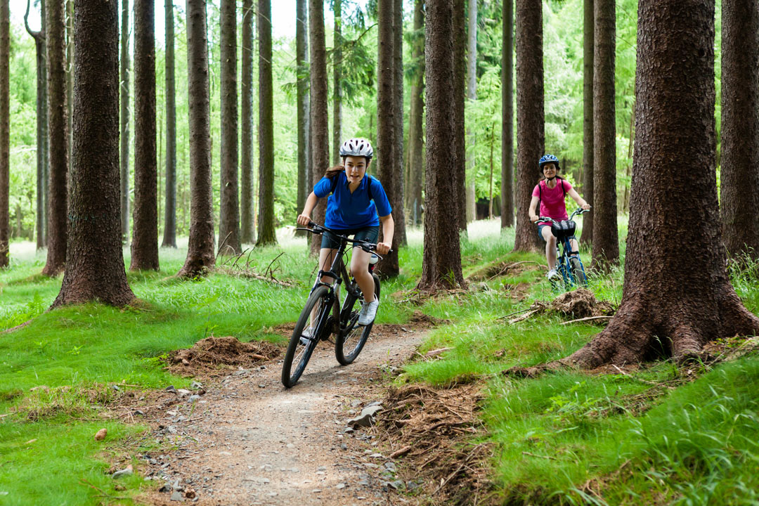 mother and daughter biking in the woods 