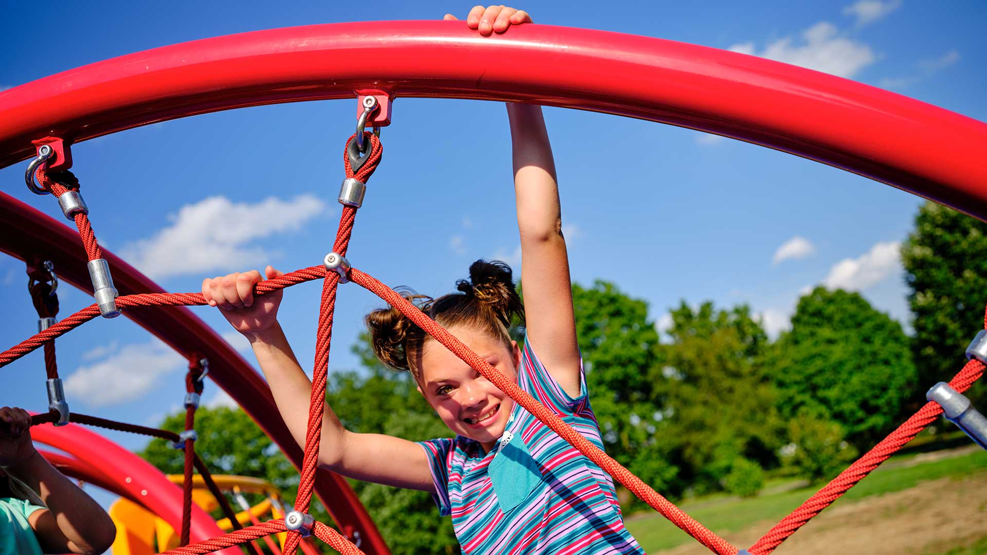 happy girl hanging from a playground