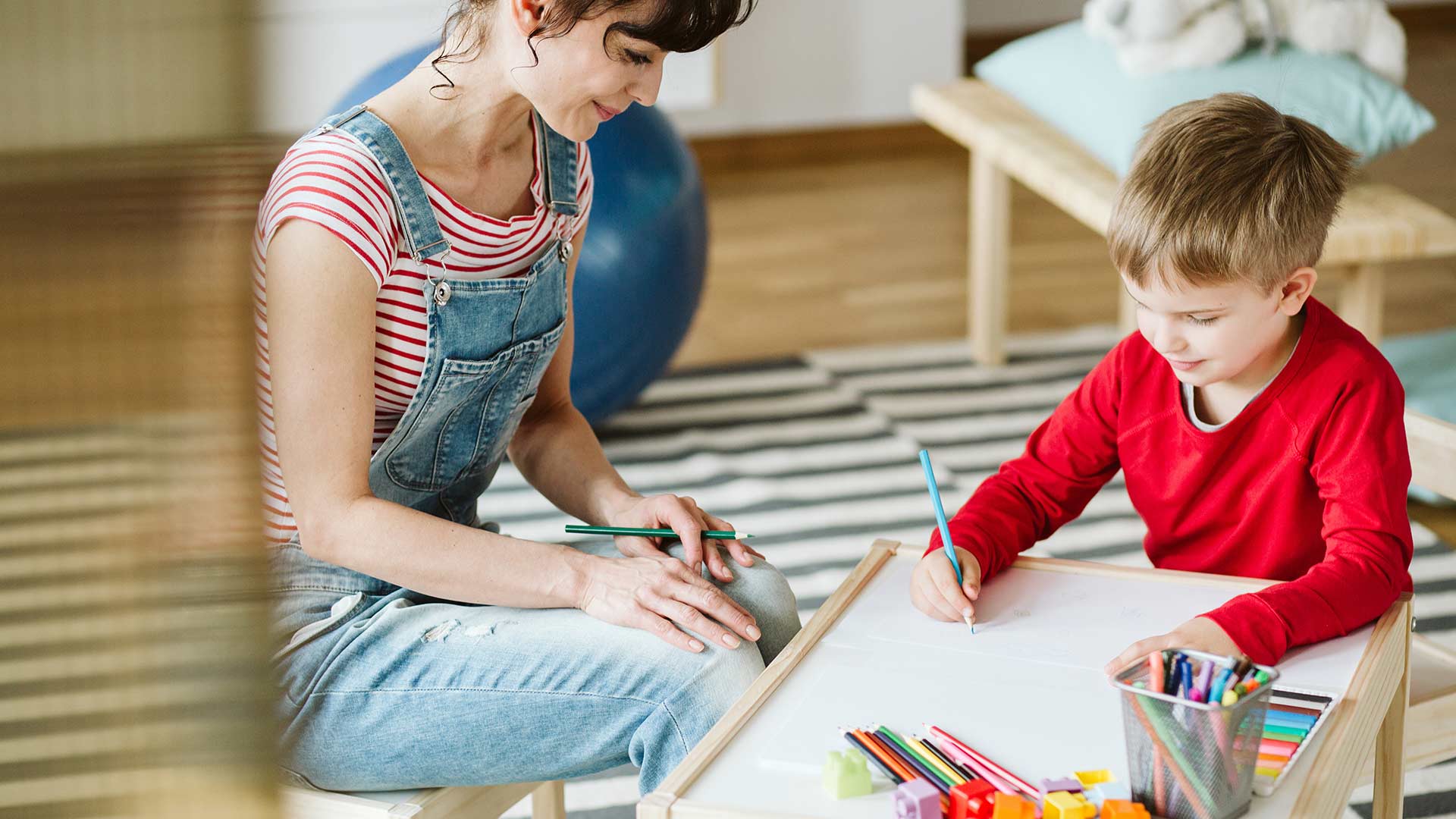 boy and therapist supervising his drawing
