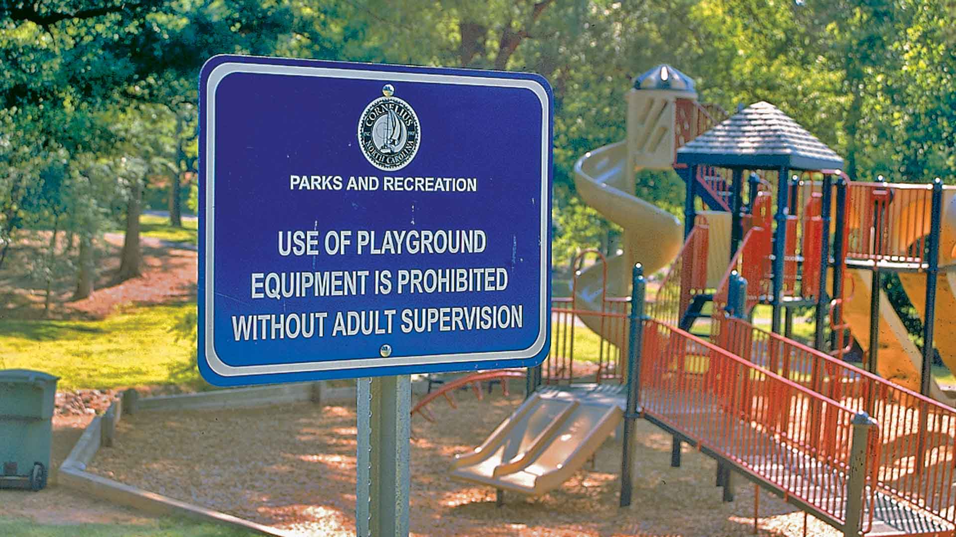 An informational sign at a city park playground
