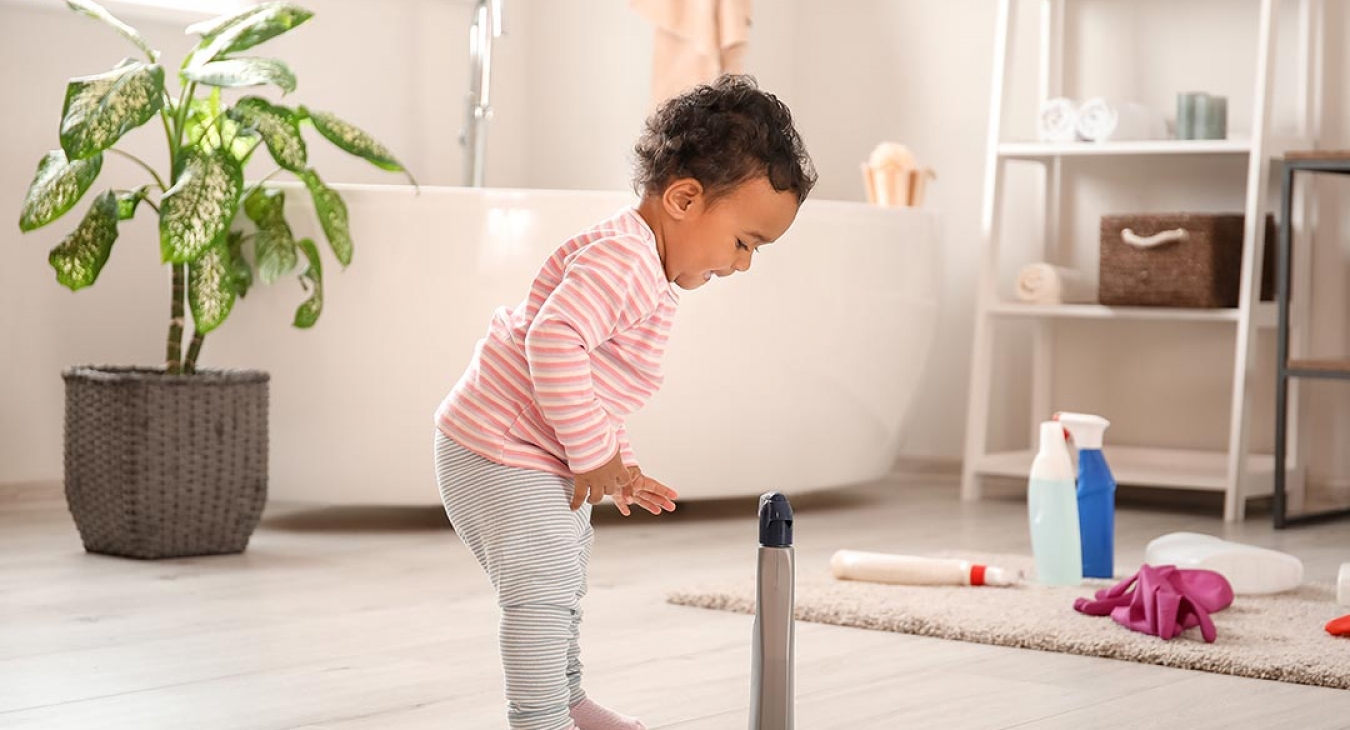 Baby playing with cleaner chemicals at home - danger
