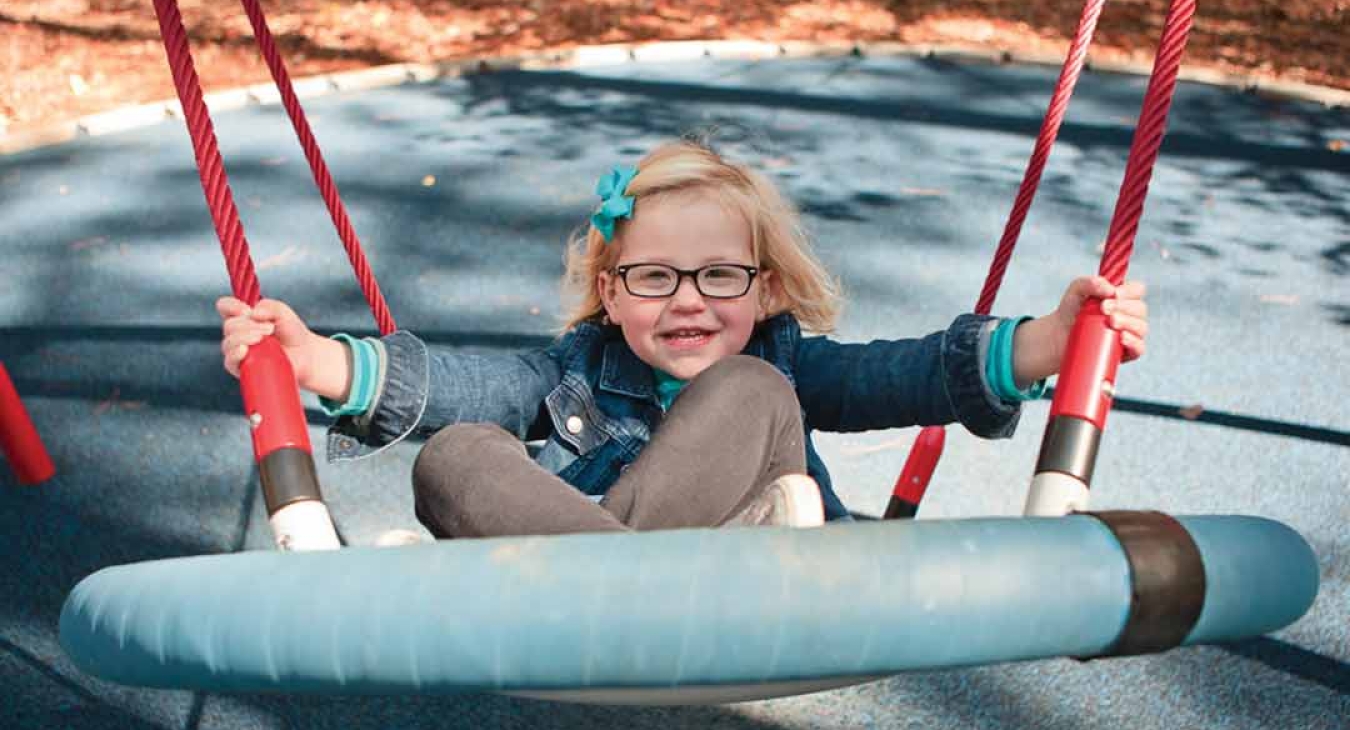 child swinging on swing set