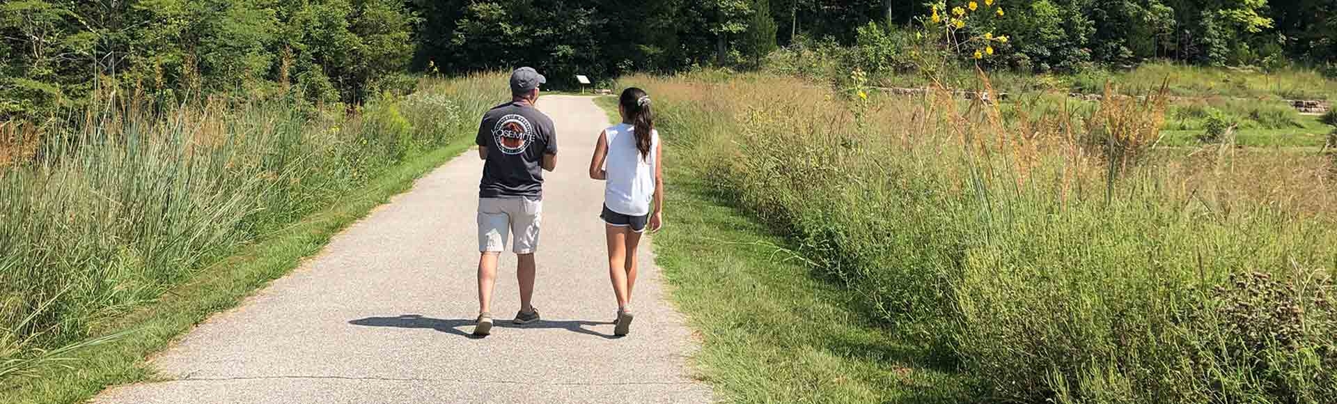 Father and daughter walking together in a park