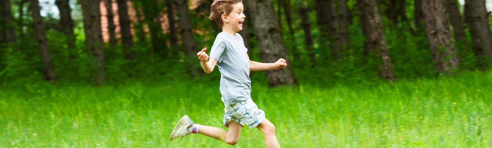 young boy playing in grass