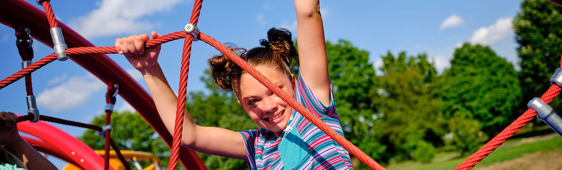 happy girl hanging from a playground