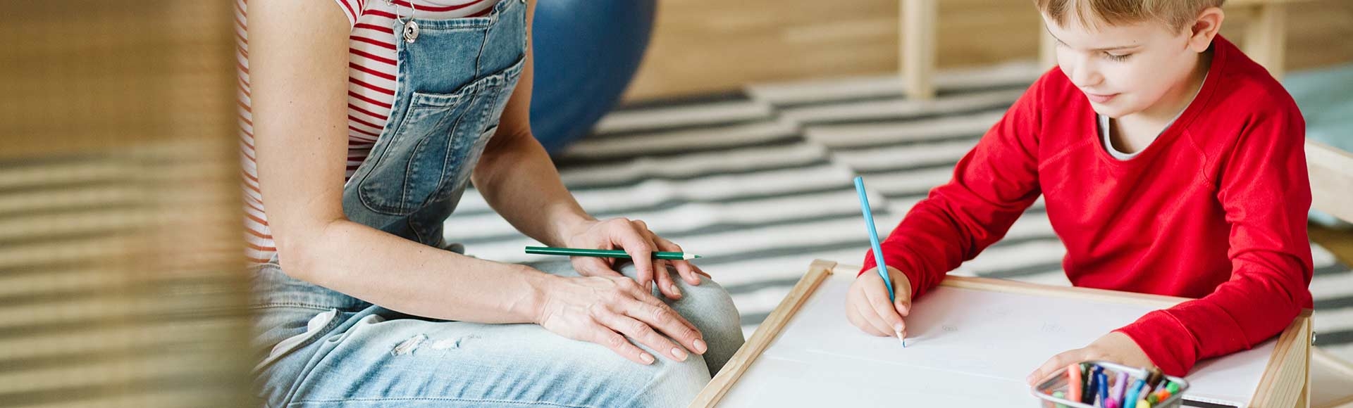boy and therapist supervising his drawing