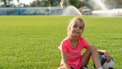Girl in grass with a soccer ball